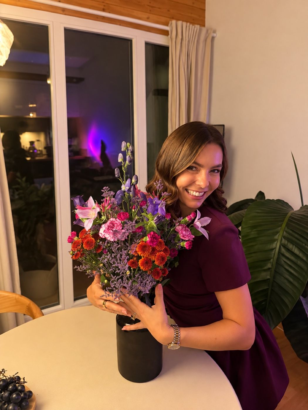 Anja mit einem Blumenstrauss am Tisch